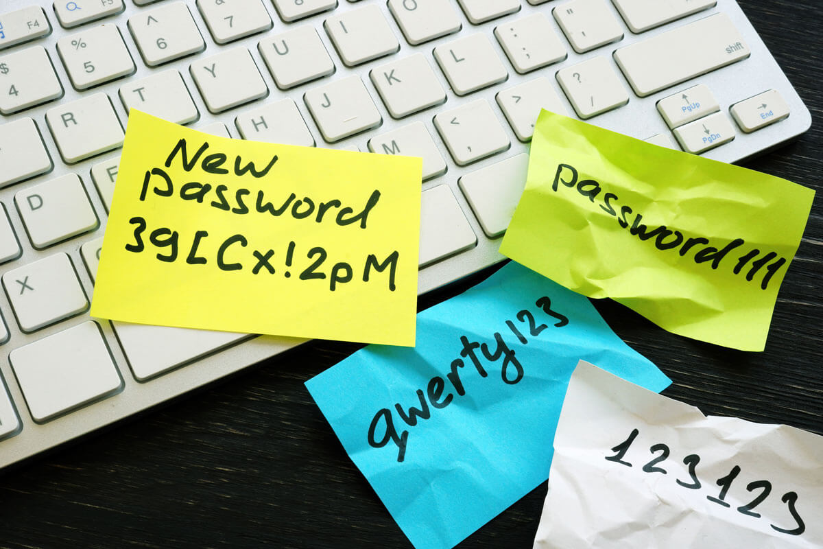 Unsichere Passwörter auf Post-it-Notizen auf einer Tastatur.